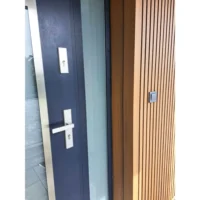 Lamel elewacyjny WPC w kolorze teak przy drzwiach wejściowych